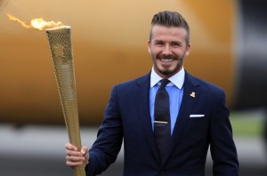 David Beckham holds the London Olympic Flame Torch as it arrives in England