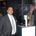 Mahesh Patel, Founder and C.E.O. of Universal Whisky Experience stands nest to his own line of Sirius Intrepid Whisky Purveyors